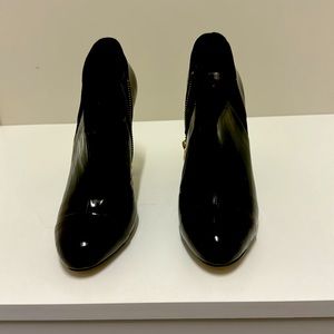 Black ankle boots with gold embellishments.